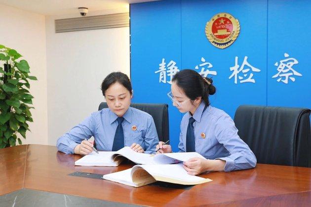 图为检察官与助理审阅案卷材料